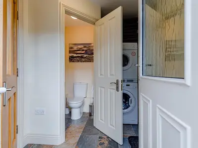 a bathroom with a toilet and a washing machine at Oak House in Keswick