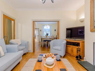 a living room with a couch and a tv and a table at Oak House in Keswick