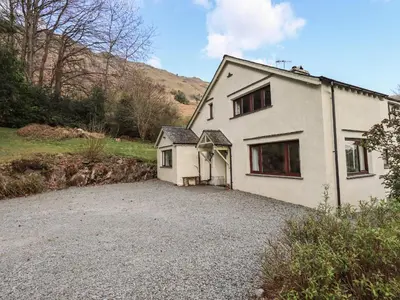 a white house with a gravel driveway at Rawfell in Ambleside