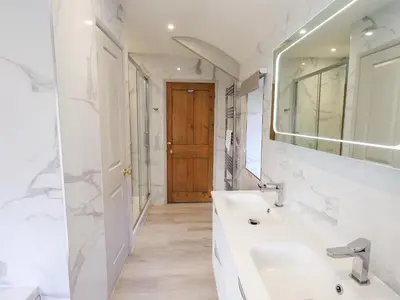 a white bathroom with a sink and a mirror at Rawfell in Ambleside