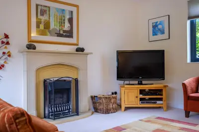 a living room with a tv and a fireplace at The Old Police House in Grasmere