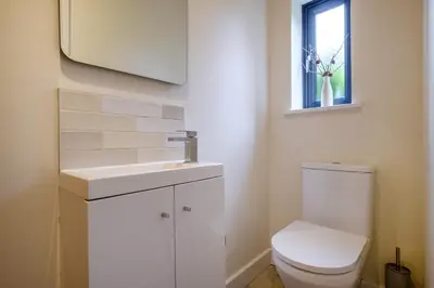 a bathroom with a toilet and a sink and a window at The Old Police House in Grasmere