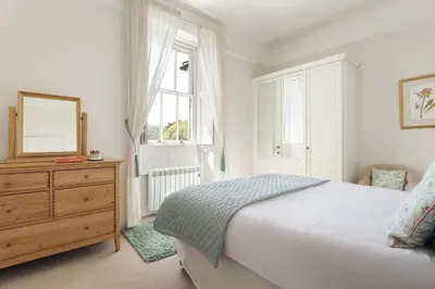 a bedroom with a bed and a dresser and a window at Wetherlam in Ambleside