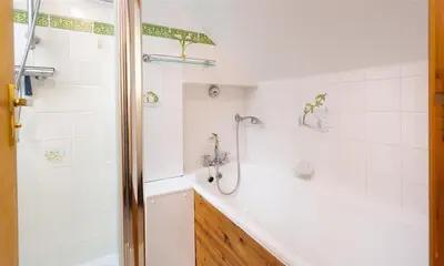 a bathroom with a shower and a tub and a sink at Lingmoor View in Ambleside