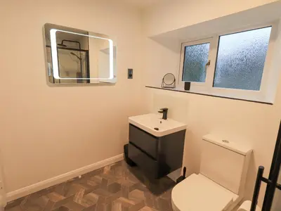 a bathroom with a sink and a toilet and a mirror at Molly's Cottage in Grasmere