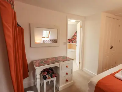a bedroom with a dressing table and a mirror at North Lodge in Grasmere