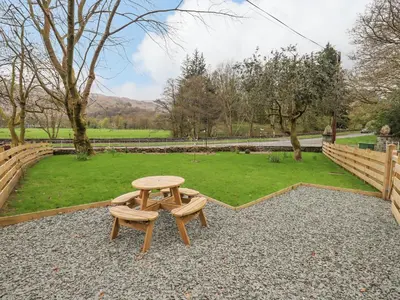 a picnic table and a bench in a park at North Lodge in Grasmere