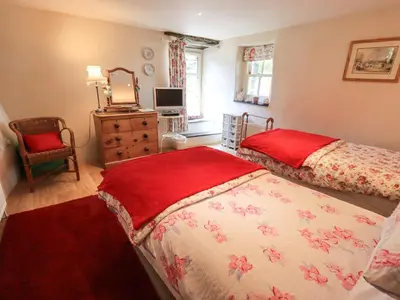 a bedroom with two beds and a dresser at Beckside Studio in Patterdale