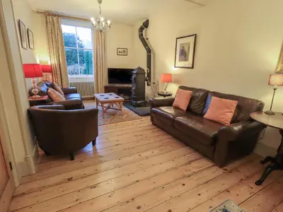 a living room with leather furniture and a wood floor at Fairy Glen in Ambleside
