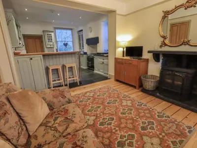 a living room with a couch and a kitchen at Fairy Glen in Ambleside