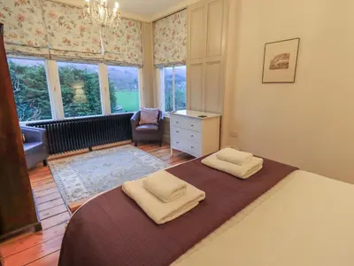 a bedroom with a bed with two towels on it at Fairy Glen in Ambleside