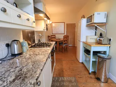 a kitchen with a white refrigerator and a counter top at Daisy Cottage in Grasmere