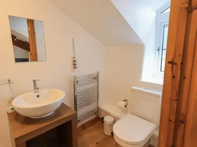 a bathroom with a white sink and a toilet at Daisy Cottage in Grasmere