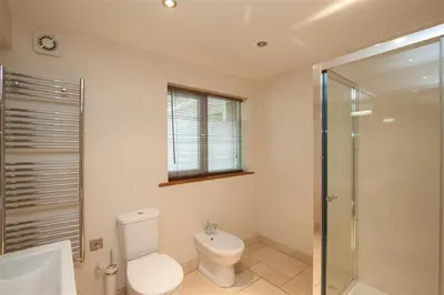 a bathroom with a toilet and a sink and a shower at Dancing Beck Cottage in Keswick