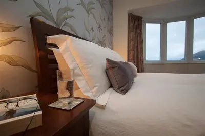 a bedroom with a bed with a pillow and a table at Riggside in Keswick