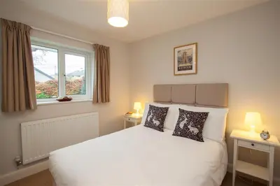 a bedroom with a white bed and a window at Riggside in Keswick