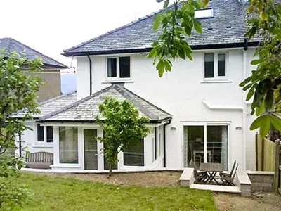 a white house with a bench in front of it at Riggside in Keswick
