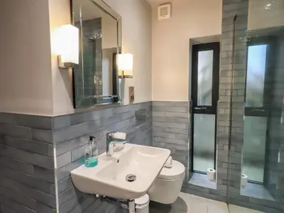a bathroom with a sink and a toilet and a mirror at Gillside in Keswick