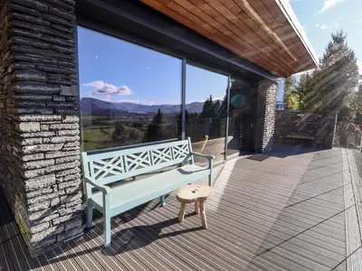 a bench on a deck with a view of the mountains at Gillside in Keswick