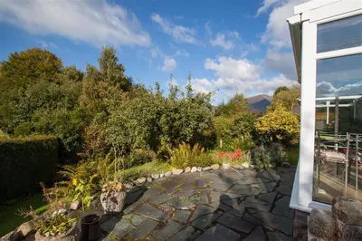 a garden with a stone walkway next to a building at Brimbles in Keswick