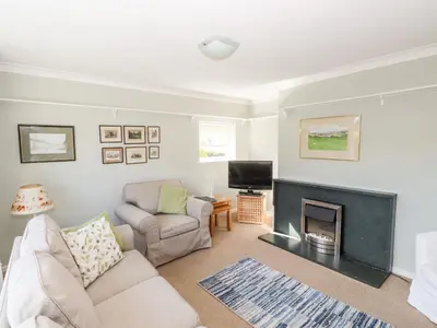 a living room with a fireplace and a tv at Brimbles in Keswick