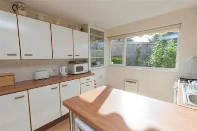 a kitchen with white cabinets and a counter top at Brimbles in Keswick