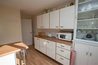 a kitchen with white cabinets and a microwave at Brimbles in Keswick