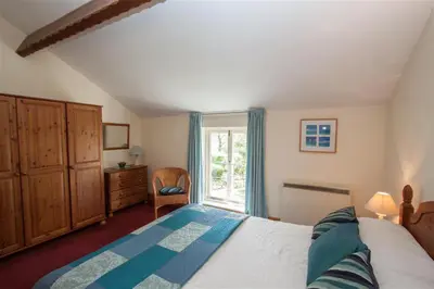 a bedroom with a large bed and a window at Grisedale Cottage in Keswick