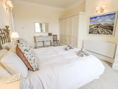 a bedroom with a white bed with pillows on it at Grisedale View in Keswick