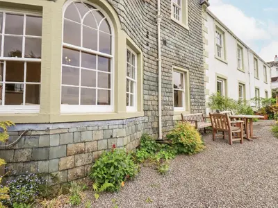 a brick house with a patio and a table and chairs at Grisedale View in Keswick