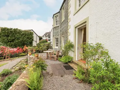 a garden outside a house with a table and chairs at Grisedale View in Keswick