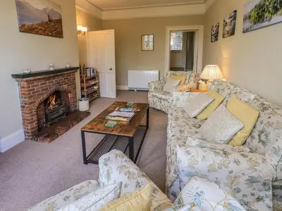 a living room with a couch and a fireplace at Sandburne Cottage in Keswick