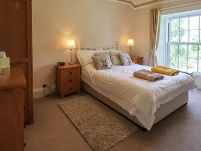 a bedroom with a bed with two pillows and a window at Sandburne Cottage in Keswick