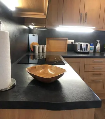a kitchen with a wooden bowl on a counter at Glenheurie Cottage in Polmood