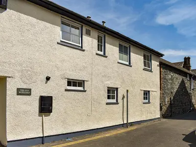 a white brick building with windows on the side of it at The Old Workshop in Keswick
