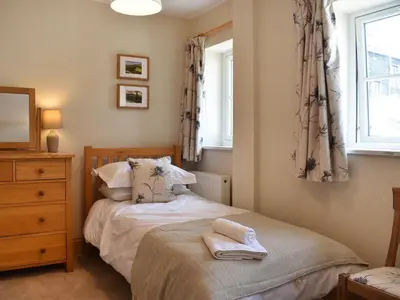a small bedroom with a bed and a window at The Old Workshop in Keswick