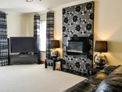 a living room with a couch and a flat screen tv at Ashgrove in Mainsriddle