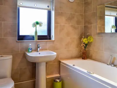 a bathroom with a sink and a tub and a toilet at Ashgrove in Mainsriddle