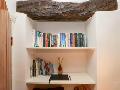 a shelf filled with books with a rock on top at Latch Cottage in Keswick