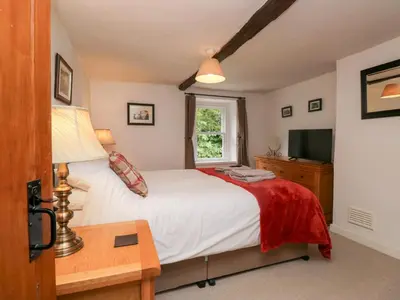 a bedroom with a bed and a window at Latch Cottage in Keswick