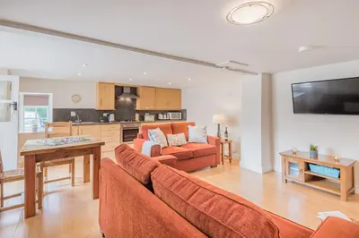 a living room with a couch and a table at farmhouse cottage in Keswick