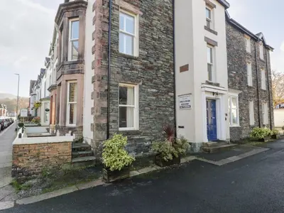 a brick building with plants in front of it at Carlton House Apartment 1 in Keswick