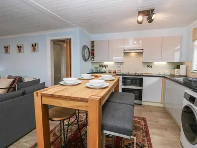 a kitchen and living room with a wooden table at The Chalet in Egremont