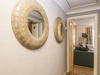 two mirrors hanging on a wall in a living room at The Chalet in Egremont