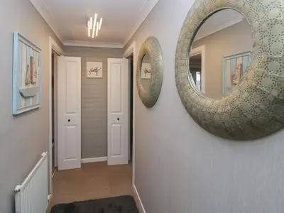 a hallway with a large round mirror on the wall at The Chalet in Egremont