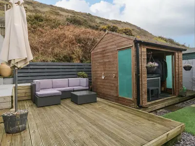 a small wooden shed with a couch and a table at The Chalet in Egremont