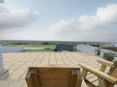 a patio with a wooden table and a bench at The Chalet in Egremont