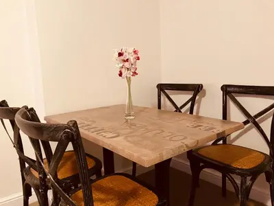 a wooden table with a vase of flowers on it at Cosy home near hospital in Carlisle