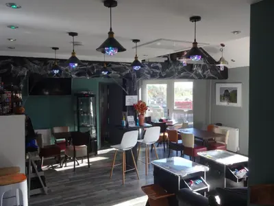 a dining room with tables and chairs and lights at John Collingwood, Bowness-on-Solway ideal for starting of finishing a walk along Hadrians Wall in Bowness-on-Solway