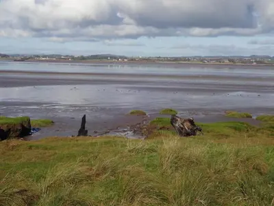 a large body of water with rocks and grass at John Collingwood, Bowness-on-Solway ideal for starting of finishing a walk along Hadrians Wall in Bowness-on-Solway